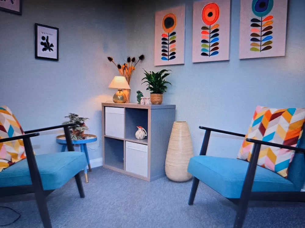 Blue armchairs and colourful artwork at Chichester Therapy Rooms